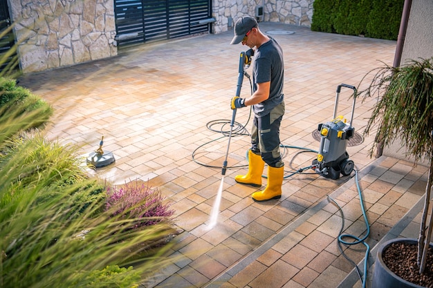 man-using-pressure-washer-clean-patio-stones-residential-garden-daylight-hours_1426-25744